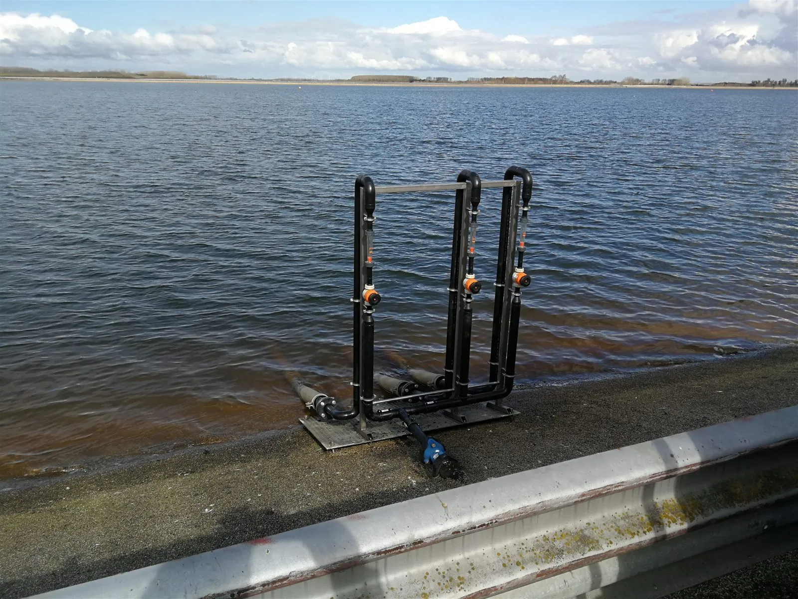 Buitenopstelling met PP doseer- en meetrek (flowmeters) bij een bassin.