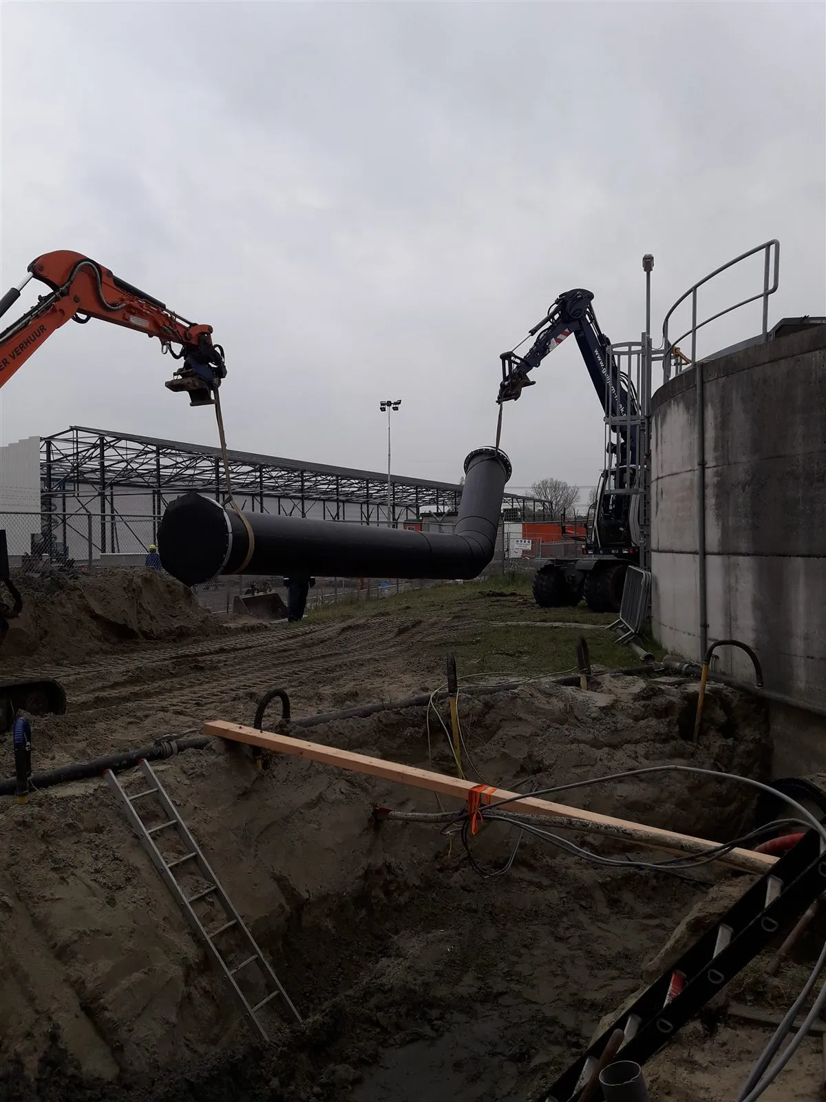 Grote 800 mm HDPE-leiding wordt met twee kranen ingehesen.